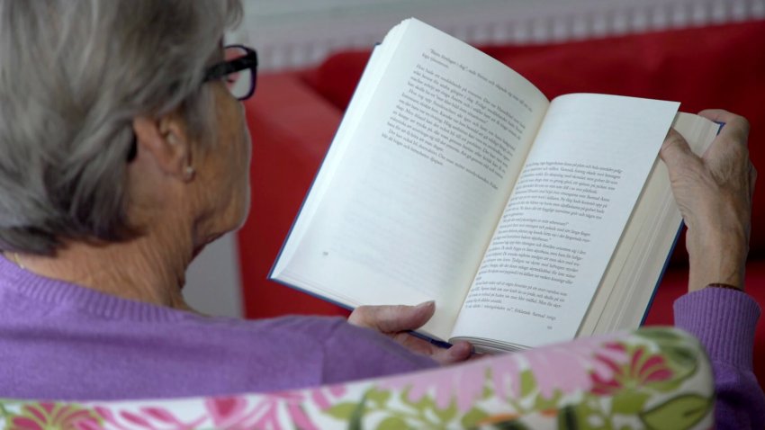 an older woman reading a book