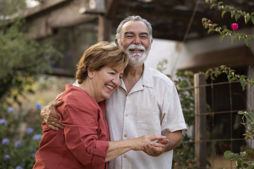 elderly couple holding each other 