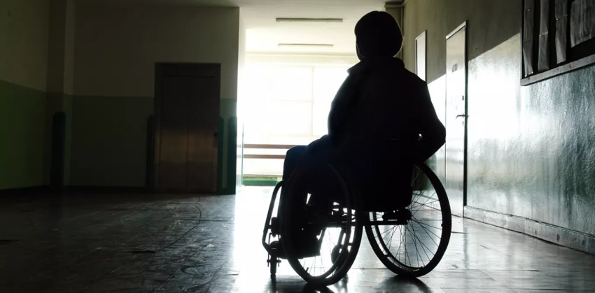 patien on wheelchair against door