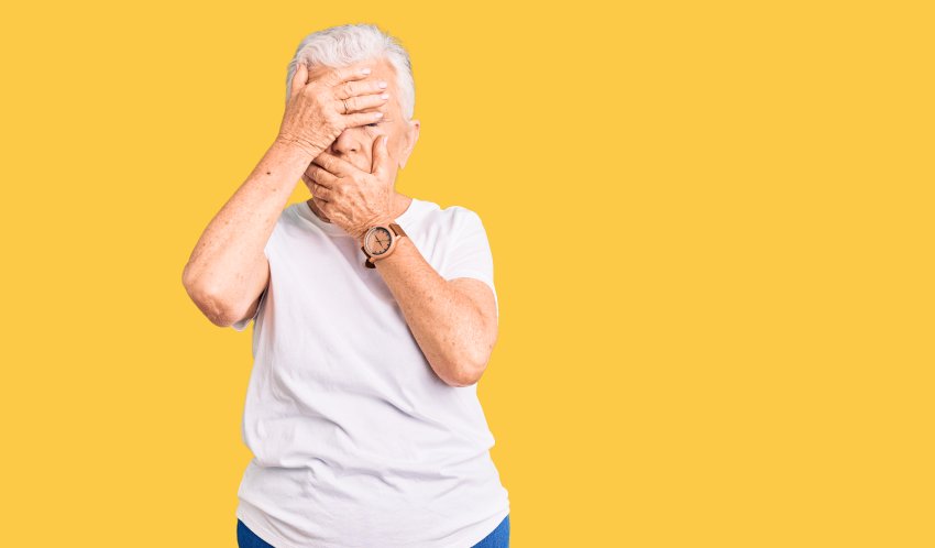 senior covering eyes mouth with hands 