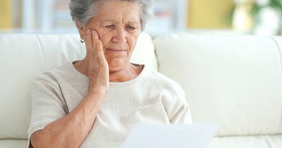 upset elderly woman reading letter