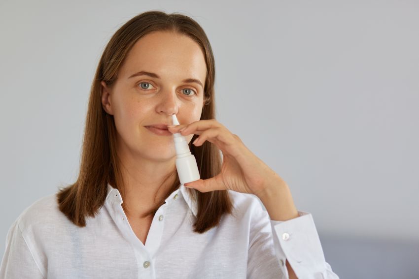 woman using nasal spray 